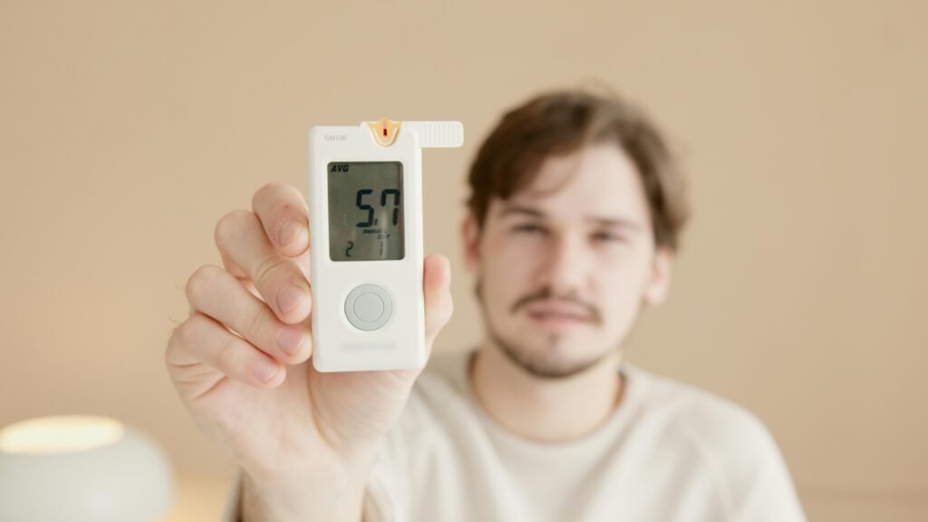 Close-up of a man holding a glucometer to check blood sugar levels, highlighting diabetes awareness.